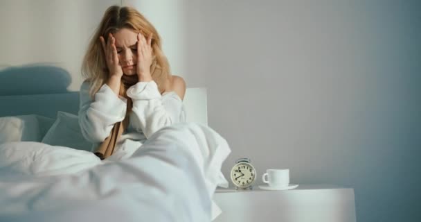 A megfázott nőnek szörnyű fejfájása van. Ellenőrzi a hwile hőmérőt, ami az ágyban pihen. 4k. — Stock videók