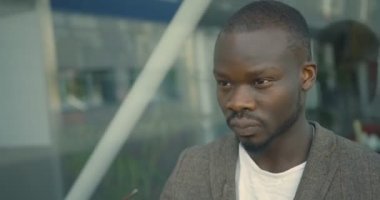 Çekici, kendine güvenen Afrikalı adamın etrafındaki kamera modern güneş gözlüğü takıyor. 4k görüntü.