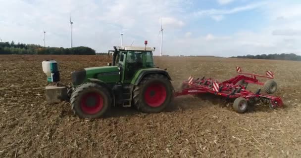 Landwirtschaftliches Konzept. Der Landwirt pflügt den Boden, während er mit dem Traktor über das Erntefeld in Deutschland fährt. Seitenansicht aus nächster Nähe. 4k Filmmaterial. — Stockvideo