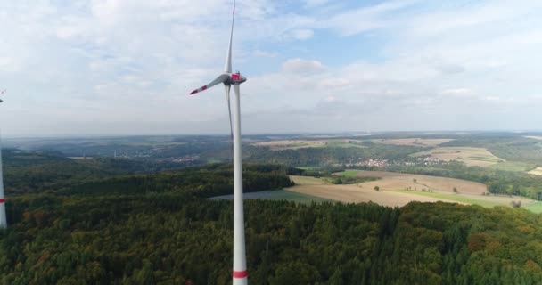 Deutschland-Rundblick. Schöne Natur von goldenen Feldern umgeben von grünem Wald mit Windrädern. Der fliegende Hubschrauber kreist um die Windmühle. — Stockvideo