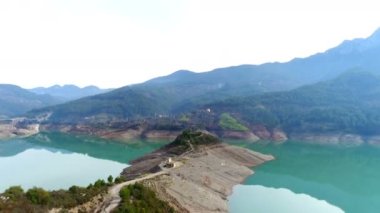 Türkiye 'nin Alanya kentindeki Taurus dağları ve güzel mavi Dim Nehri üzerinde uçan helikopter. Küçük adadaki eski harabe ev. 4k.