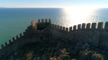 Hava helikopteri Alanya kalesi ve güzel mavi Akdeniz üzerinde güneşli bir günde yüzen tekneyle uçuyor. Antalya ilinin, Türkiye. 4k, ağır çekim..
