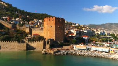 Akdeniz kıyısındaki Alanya kasabası. Altanya ilinin, Türkiye. Uçan helikopter. Ünlünün yakın plan görüntüsü. Fostress Kulesi. Yavaş çekim, 4k.