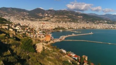 Akdeniz tarafından aşırı yıkanmış dağlardaki güneşli şehir Alanya 'nın manzarası. Antalya ilinin, Türkiye. Uçan helikopter görüntüleri..