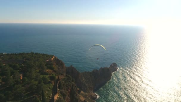 Парашутний стрибун літає над горами Тавр, які промиваються Середземним морем в сонячній провінції Анталія в Туреччині. Прекрасні природні кадри з копіювальника. — стокове відео