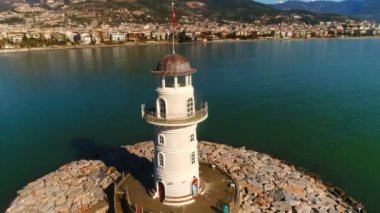 Türkiye 'nin Antalya ilinin güzel Alanya kentinin arka planında, Akdeniz kıyısındaki sarkaç etrafında uçan hava helikopteri görülüyor..