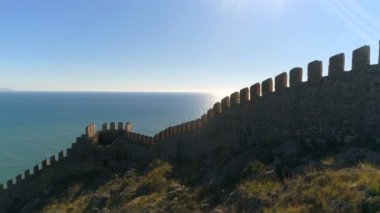 Türkiye 'nin Antalya ilinin Alanya kentindeki kale duvarlarından güneşli güzel Akdeniz' in helikopter görüntüleri