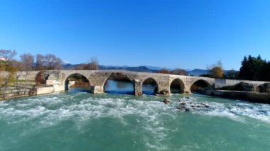 Antalya ilinin Eurymedon Nehri üzerindeki eski Seljuk köprüsü üzerinde insansız hava aracı uçurmak. 4k, ağır çekim..