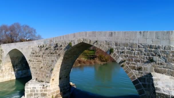 Widok panoramiczny. Dron przelatuje nad historycznym mostem Seljuk nad piękną rzeką Eurymedon w prowincji Antalya w Turcji. Zwolnij, 4k. Czas letni. — Wideo stockowe