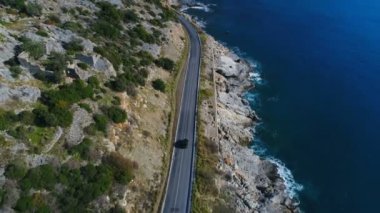 Antalya 'nın Gazipasa ilçesinde Akdeniz tarafından sular altında bırakılan yeşil Taurus Dağları' nda dar yol boyunca giden siyah arabayı helikopter takip ediyor..
