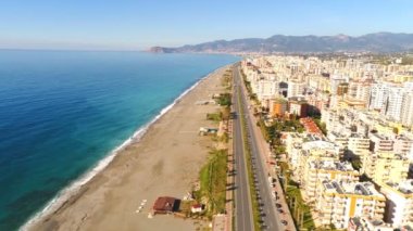Mahmutlar, Taurus dağları ve Akdeniz 'in kıyılarını saran güzel şehir manzarası. Antalya ilinin, Türkiye. İHA görüntüleri, 4K.