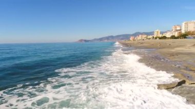 Antalya ilinin güzel Mahmutlar ilçesinin sahil şeridinde beyaz deniz köpüğüyle dalgalar halinde ilerliyor. Yavaş çekim, 4k.