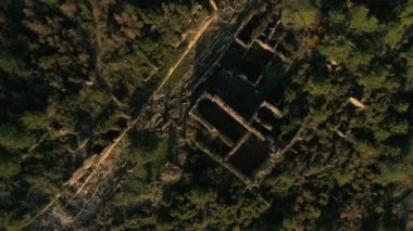 İnsansız hava aracının, ormanlarla kaplı, kayalık Taurus Dağları 'ndaki eski harabe Syedra Kalesi' nde daireler çizmesi ve tırmanması. Türkiye 'nin Antalya ilinde. 4k, ağır çekim..