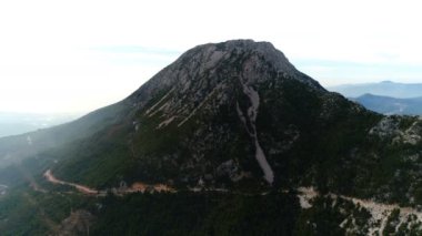 Uçan helikopterin yavaş hareketi. Yeşil, kalın ağaçlarla kaplı Taurus Dağları 'nın kayalarının yakın görüntüsü. Yaz zamanı. 4 bin. Alanya, Türkiye.