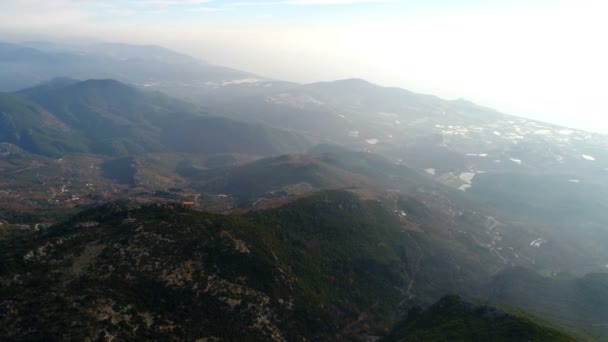 Alanya, Tuskey, Vuelo aéreo del dron sobre hermosas montañas soleadas brumosas de Tauro cubiertas de colinas, bosques, prados, pueblito y que fluyen a lo largo del río Dim. — Vídeos de Stock