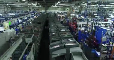 Araba fabrikasının içinde. Arabanın elektrik kablolarını, kablolarını ve diğer şeyleri üreten insanlar. İş yerinde hareketli bir manzara. 4k.