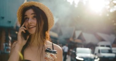 Islak saçlı, bikinili ve telefonda biriyle konuşurken gülümseyen çekici bir genç kadın. Yaz zamanı, meslek