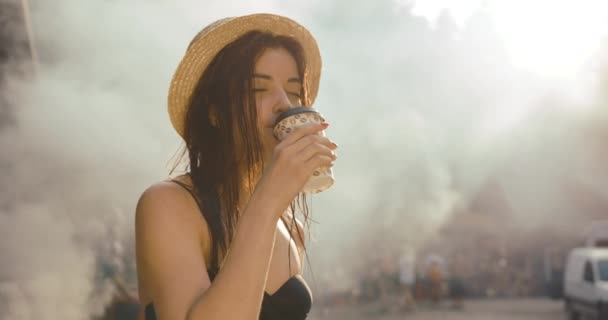 Vocation in the mountains. Girl drinks coffee standing before the fire. Summer time — Stock Video