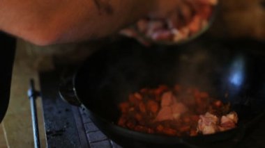 Dışarıda yemek pişirmek. Doğada piknik. Et pişiriyorum. Yemek pilavı. Açık hava serisinde kazanda pilav pişirmek. Kuzu eti ve soğan parçaları tavada kızgın yağda kızartılır..