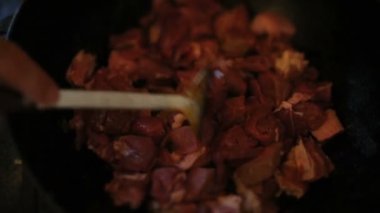 Dışarıda yemek pişirmek. Doğada piknik. Et pişiriyorum. Borç çorbası pişiriyorum. Açık hava serisinde kazanda Borsch pişirme. Et, soğan ve pancar parçaları ateşte kızarır.