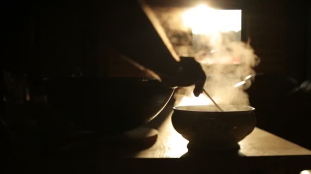 Dışarıdaki yangında bir kazanda yemek pişirmek. Et, soğan ve havuç parçaları ateşte kaynar suda kızartılır. Paket yemek. Kazanda sıcak yemek kaynıyor. — Stok video