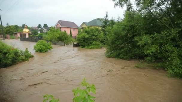 Flooding of villages in Ukraine in the Carpathians. Flood. Dirty water flows in a strong current between the houses. Ecological catastrophe — Stock Video