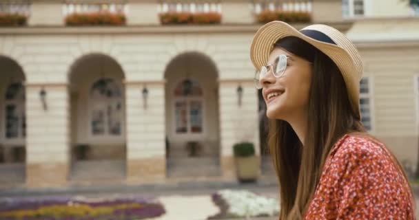 Jonge fermale toerist in oude Europese stad. Charmante jonge vrouw in rode jurk loopt met een fiets en kijkt om zich heen naar prachtige architectuur — Stockvideo