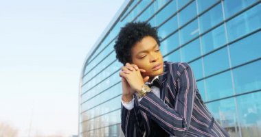 4 bin. Seyahat et. Çekici, soyulmuş takım elbiseli Afro-Amerikalı kadın modern cam bina inşaatından önce bavula oturur ve bir şey ya da birini bekler. İş kadını ya da öğrenci