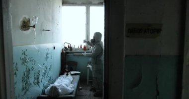 Koruyucu giysiler ve gaz maskesi giyen bilim adamı tehlike bölgesinde. Kimya. Radyoaktif tehdit