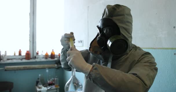 Wetenschapper arts in beschermende kleding en gasmasker in gevarenzone. Injecteren voor een patiënt — Stockvideo