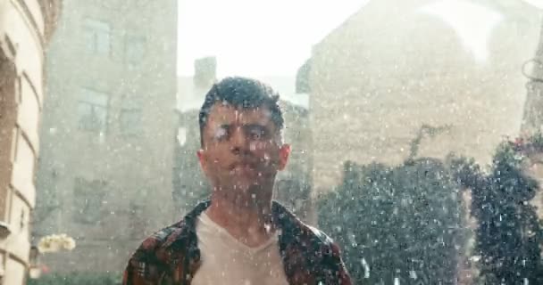 ハンサムな若い男が手を上げて頭を上げて感情的に叫んでいます。雨の日。4k映像だ。自由の概念. — ストック動画
