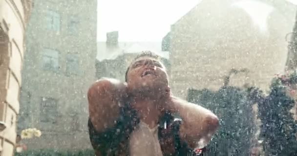 Entspannt schaut Brunet nach oben und genießt den Regen während des sonnigen Tages. 4k Filmmaterial. — Stockvideo