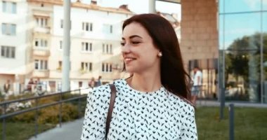 Güzel gülüşlü güzel, modaya uygun esmer cadde boyunca yürürken cep telefonunda sohbet ediyor, mesajlaşıyor ve geziniyor..