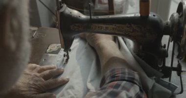 Yaşlı erkek eller eski el yapımı makineye dikiş dikiyorlar. Yüzü yok. Yakın plan. 4k görüntü.