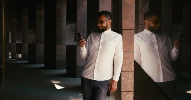 O homem africano bonito é muito feliz depois de receber o sms com boas notícias ao ar livre. Retrato emocional. — Vídeo de Stock