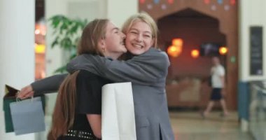 Şık arkadaşlar alışveriş merkezinde yürüyor, gülüyor ve sarılıyorlar. Mutlu arkadaşlar başarılı bir alışverişten sonra evlerine giderler. İki güzel kadın alışveriş merkezinin içinde geziniyor ve alışverişlerini izliyorlar. 4K