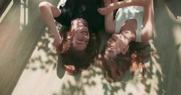 Acercamiento retrato de belleza de un atractivo feliz joven riendo mujeres acostadas con el pelo rizado a su alrededor, sonriendo alegremente con dientes perfectos. Retrato al aire libre de hermosas chicas jóvenes — Vídeo de stock