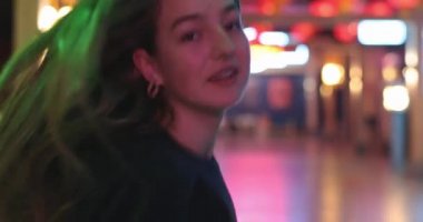 Çekici bir genç kadının güzel portresi. İleri gider, esmer saçlarıyla oynar ve dans etmeye başlar. Güzel kızların gözlerindeki büyüleyici bakış. 4K video