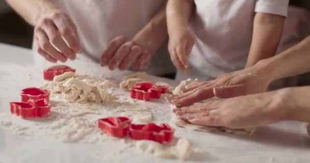 Крупним планом портрет охайних рук і як вони замішують тісто і роблять фігури. Молода сім'я готує на кухні. Біла затишна кухня і спокійна сімейна атмосфера. відео 4K — стокове відео