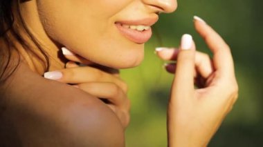 Ormanda bir gelinin portresi, bir gelinlik içinde saçının bir buklesine dokunuyor, yakın çekim, yavaş çekim..