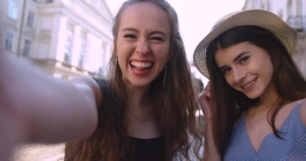 Twee gelukkige vriendinnen die buiten zijn op een mooie zonnige dag. mooi meisje maken selfies terwijl het hebben van plezier buiten — Stockvideo