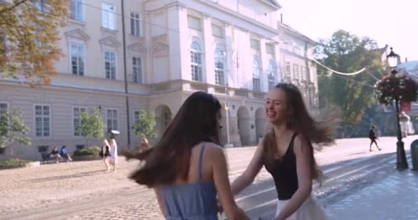 Dvě atraktivní mladé ženy tančí a baví se na ulici. — Stock video