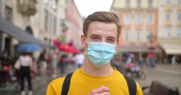 Mladý muž teenager si sundá ochrannou modrou masku a. Myšlenka osobních ochranných prostředků proti koronaviru — Stock video