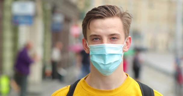 Mladý muž v ochranné masce obličeje jako preventivní opatření proti čínskému koronaviru COVID-19. Hipster muž s profesionální obličejovou maskou na ochranu proti znečištění nebo nCov-19. Osobní ochrana. — Stock video