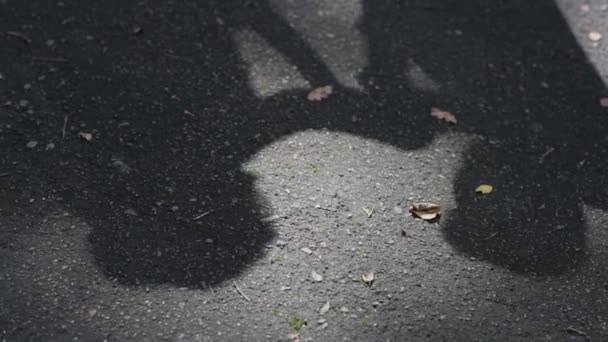 Schatten des Hochzeitspaares auf dem Asphalt, Mann küsst Frauenhand. Silhouette des Schattens der Frischvermählten auf dem Fußboden — Stockvideo