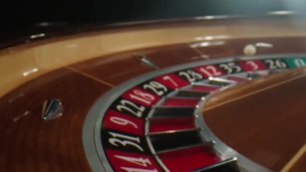 Kasino roulette i rörelse. Vit boll faller till noll medan hjulet snurrar. Roulettebordet i kasinot — Stockvideo