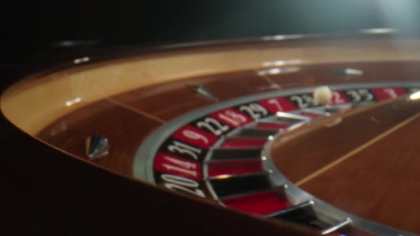 Ruleta del casino en movimiento. La bola blanca cae a cero mientras la rueda gira. La mesa de ruleta en el casino — Vídeos de Stock