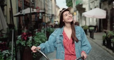 Şehirde Bisikletli Gülümseyen Hippi Kız. Bokeh ve Kopyalama Uzayı ile Tone ve Filtrelenmiş Fotoğraf. Şehir Gençliği Yaşam Tarzı Konsepti