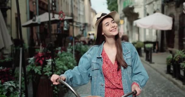 Uśmiechnięta hipsterka z rowerem w mieście. Fotografia nastrojona i filtrowana z Bokeh i Copy Space. Koncepcja miejskiego stylu życia młodzieży — Wideo stockowe