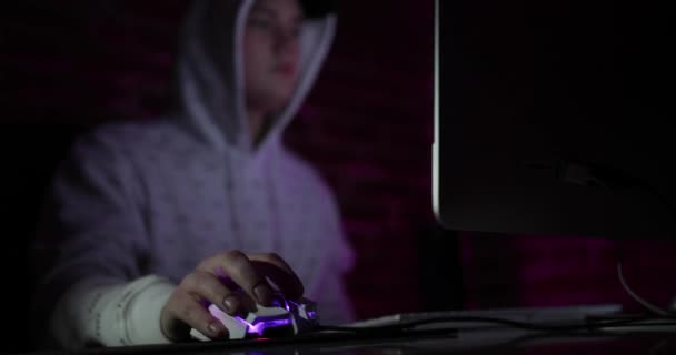 Oldalnézet hacker számítógép segítségével digitális interfész ülve, homályos belső pultnál. Hackerek és adathalász koncepció — Stock videók